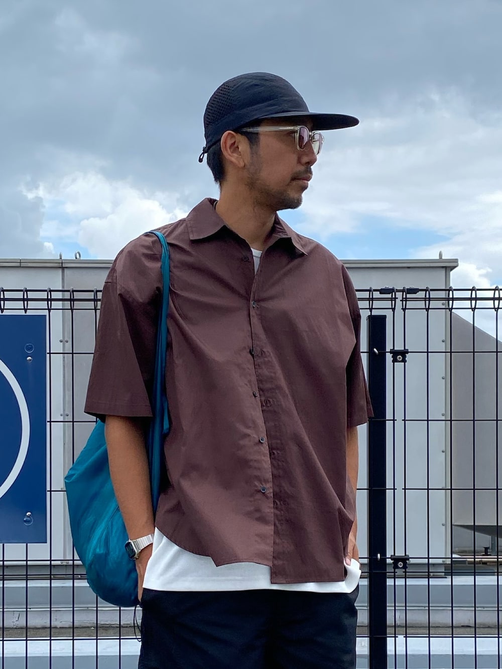 ブラウン系のシャツ/ブラウス、ホワイト系のタンクトップ、ブルー系のショルダーバッグを着用したメンズの夏コーディネートの4枚目の写真