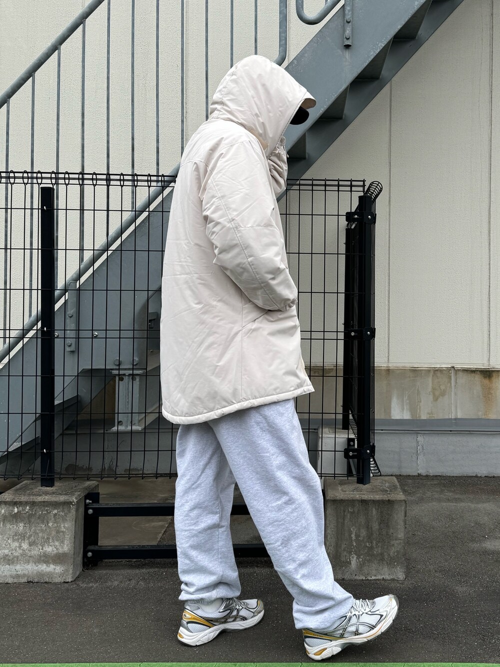 ブラック系のダウンジャケット/コート、グレー系のスウェットパンツ、ホワイト系のスニーカーを着用したメンズの冬コーディネートの6枚目の写真