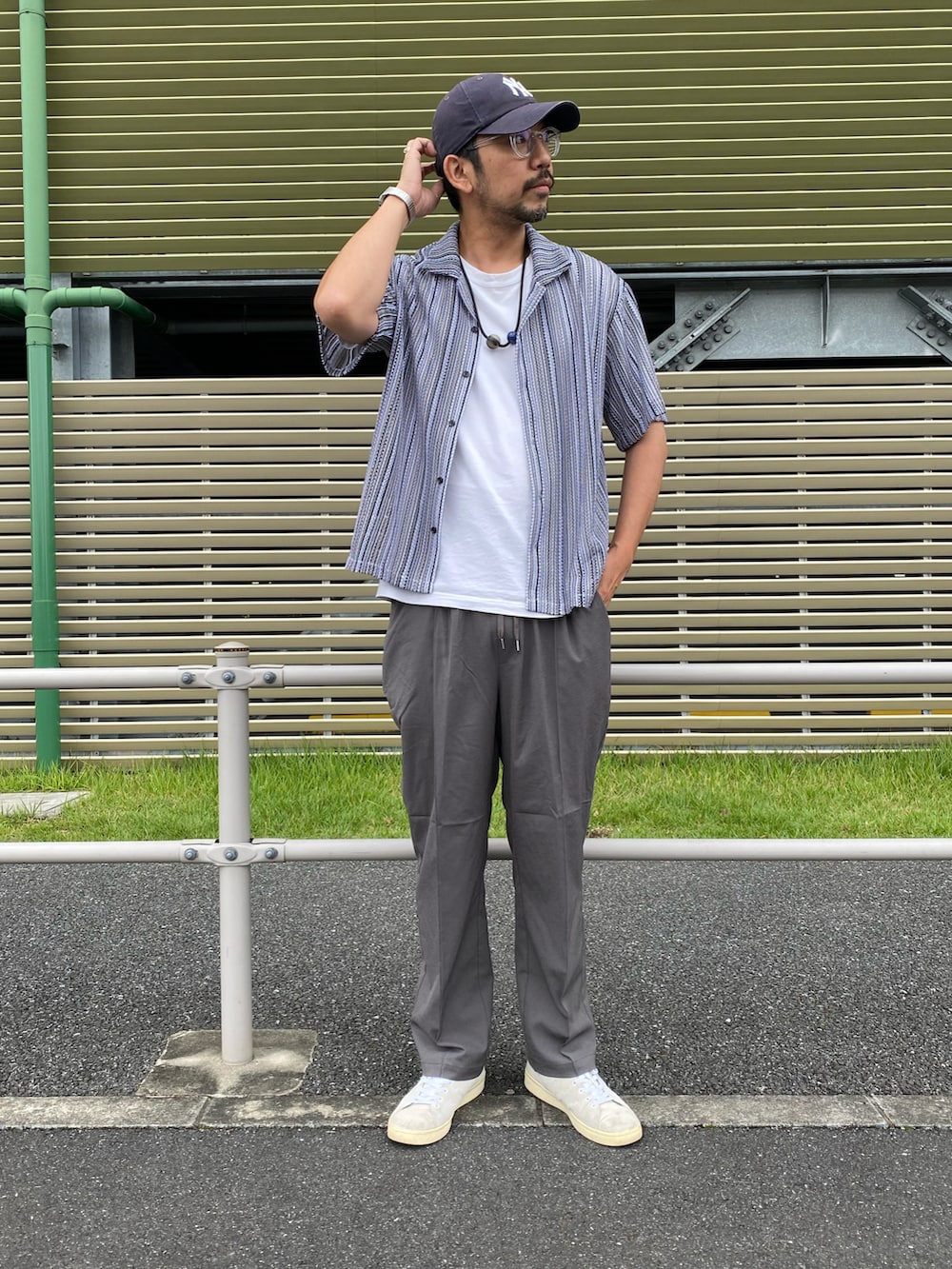グレー系のシャツ/ブラウス、グレー系のスラックス、ホワイト系のスニーカーを着用したメンズの夏コーディネートの2枚目の写真
