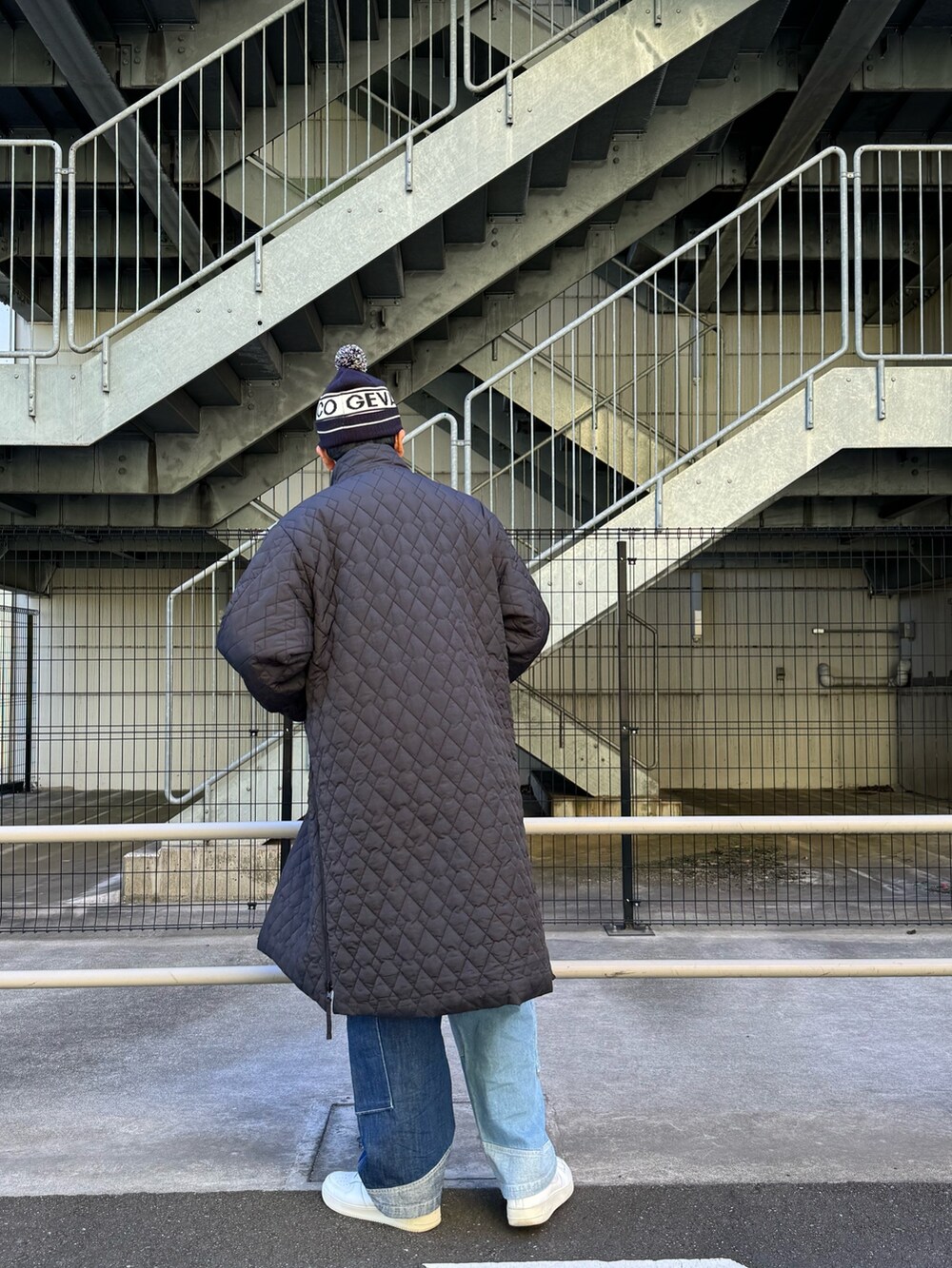 ブラック系のモッズコート、ブルー系のデニムパンツ、ホワイト系のスニーカーを着用したメンズの秋コーディネートの6枚目の写真