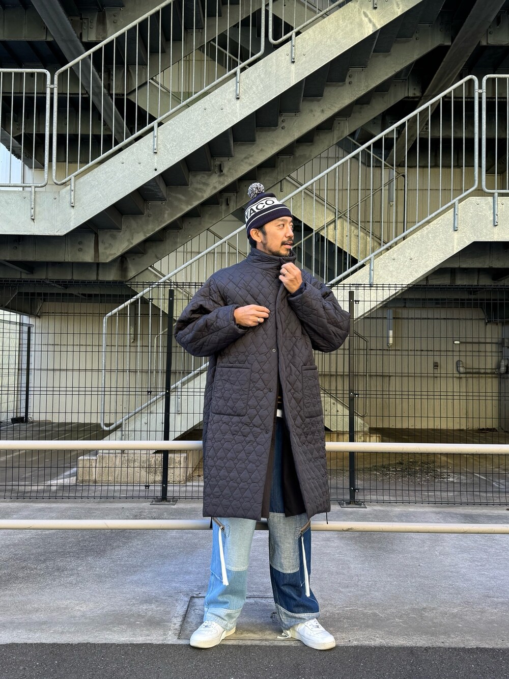 ブラック系のモッズコート、ブルー系のデニムパンツ、ホワイト系のスニーカーを着用したメンズの秋コーディネートの8枚目の写真