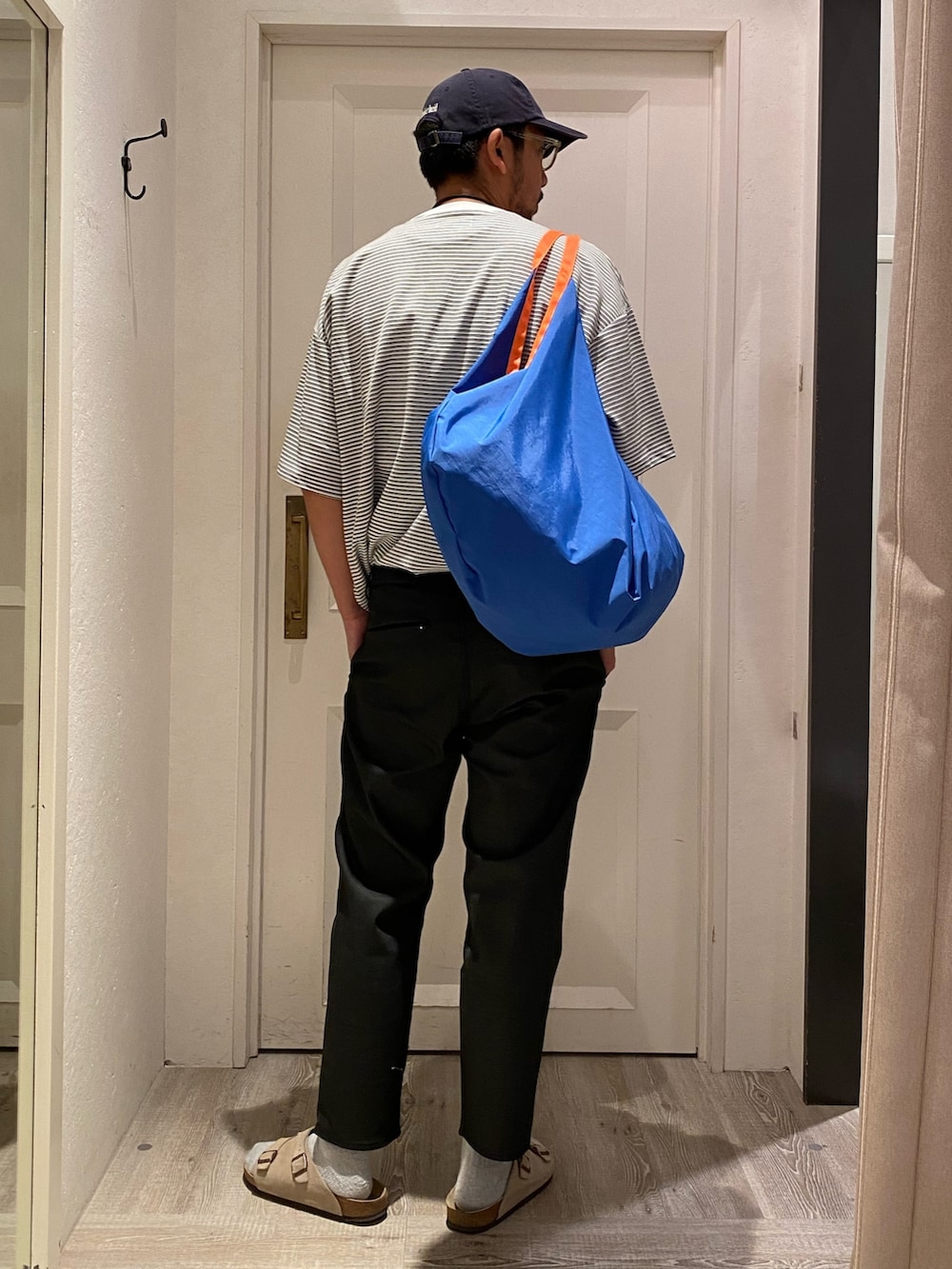 ホワイト系のTシャツ/カットソー、ブルー系のデニムパンツ、ベージュ系のサンダルを着用したメンズの夏コーディネートの4枚目の写真