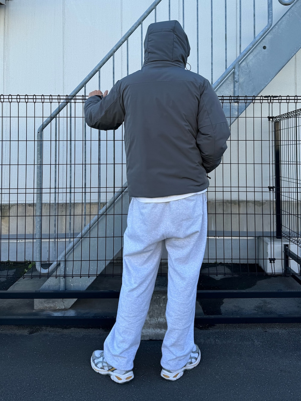 ブラック系のダウンジャケット/コート、グレー系のスウェットパンツ、ホワイト系のスニーカーを着用したメンズの冬コーディネートの7枚目の写真