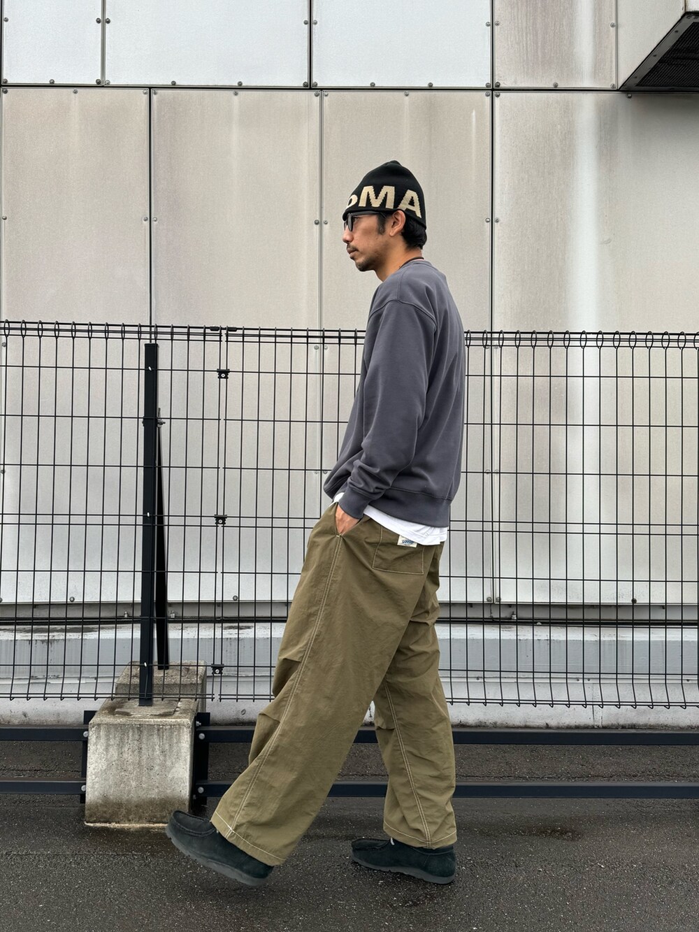 グレー系のスウェット、ブラック系のカーゴパンツ、ブラック系のブーツを着用したメンズの秋コーディネートの4枚目の写真