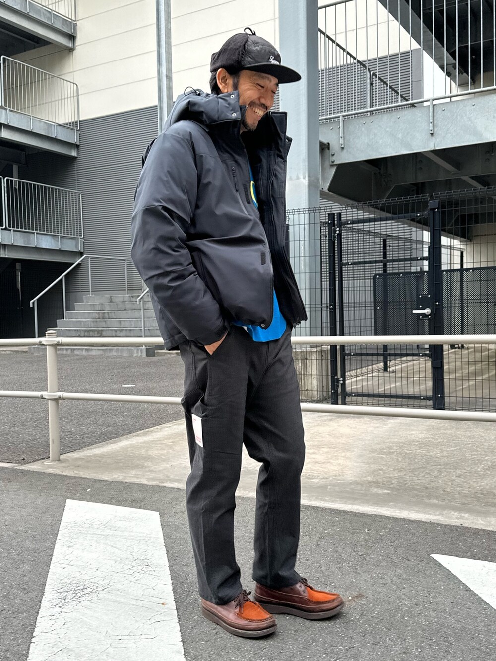 ブラック系のダウンジャケット/コート、ブルー系のTシャツ/カットソー、ブラック系のデニムパンツを着用したメンズの冬コーディネートの4枚目の写真