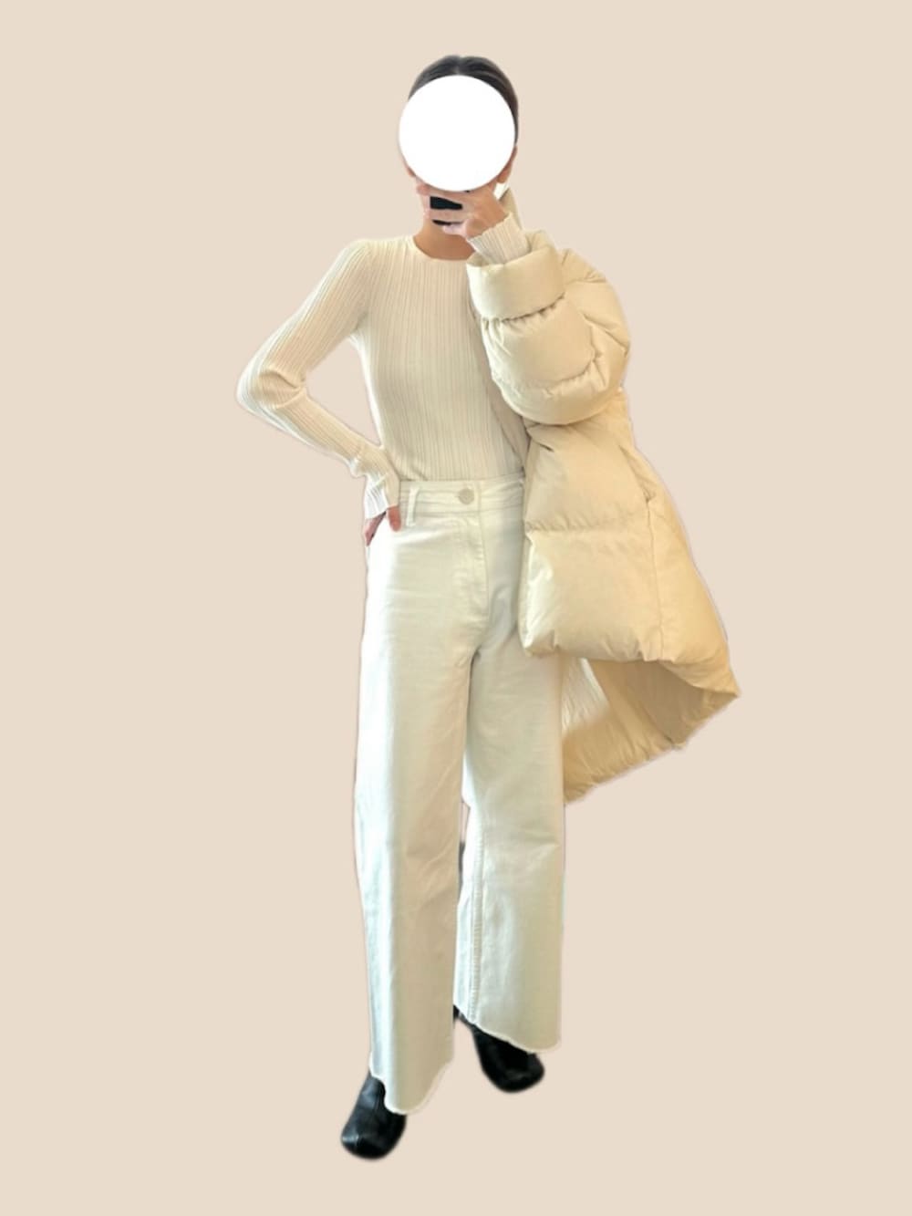 ブラック系のブーツ、ホワイト系のニット/セーター、ホワイト系のダウンジャケット/コートを着用したレディースの冬コーディネートの2枚目の写真