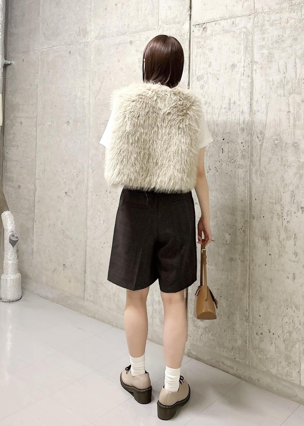 ベージュ系のベスト、ホワイト系のTシャツ/カットソー、ブラウン系のその他パンツを着用したレディースの秋コーディネートの5枚目の写真