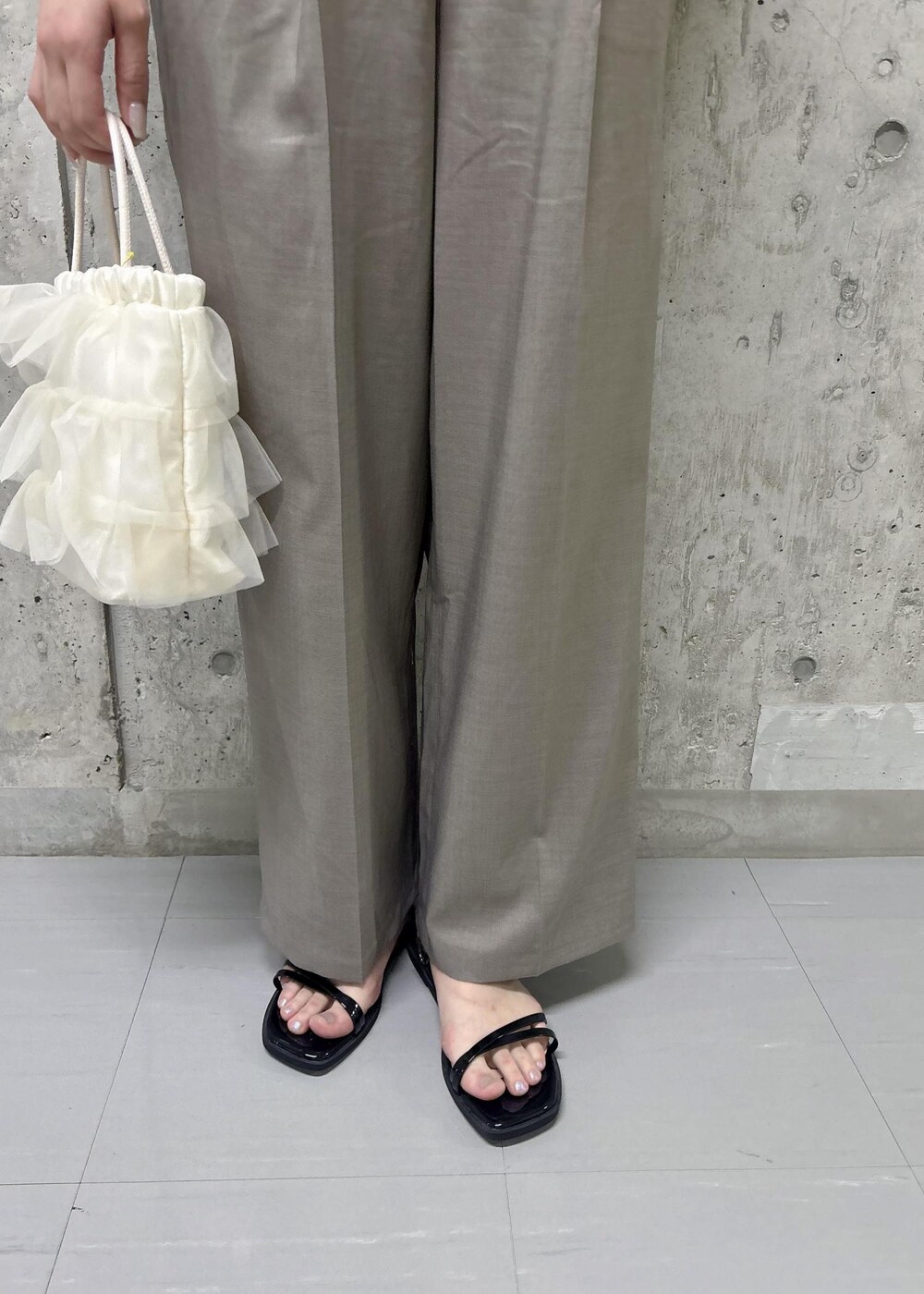 ブラック系のサンダル、ホワイト系のショルダーバッグ、ホワイト系のシャツ/ブラウスを着用したレディースの夏コーディネートの10枚目の写真