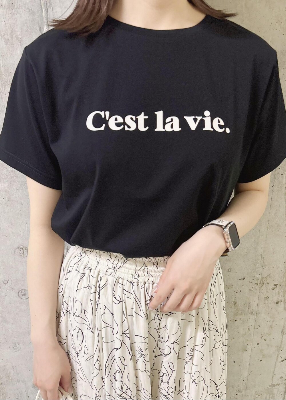 ホワイト系のトートバッグ、ブラック系のTシャツ/カットソー、ゴールド系のサンダルを着用したレディースの夏コーディネートの7枚目の写真