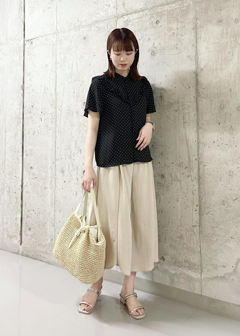 ブラック系のシャツ/ブラウス、ホワイト系のトートバッグ、シルバー系のサンダルを着用したレディースの夏コーディネートの2枚目の写真