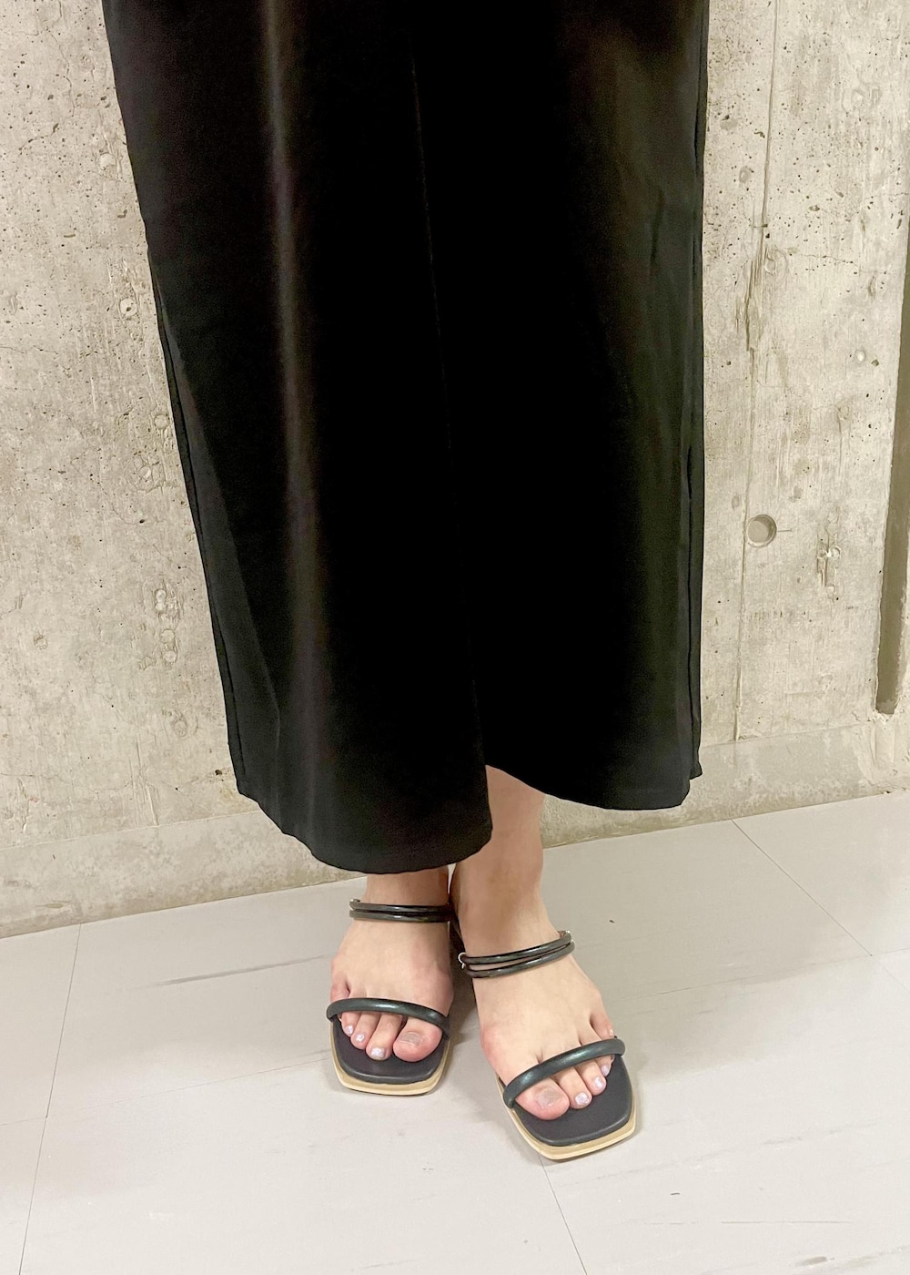 オレンジ系のショルダーバッグ、ブラック系のサンダル、ブラック系のワンピースを着用したレディースの夏コーディネートの5枚目の写真