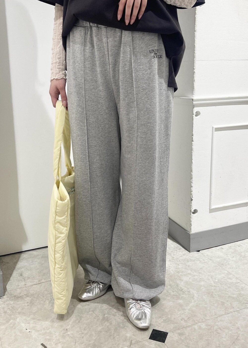 ホワイト系のTシャツ/カットソー、シルバー系のパンプス、イエロー系のトートバッグを着用したレディースの春コーディネートの5枚目の写真