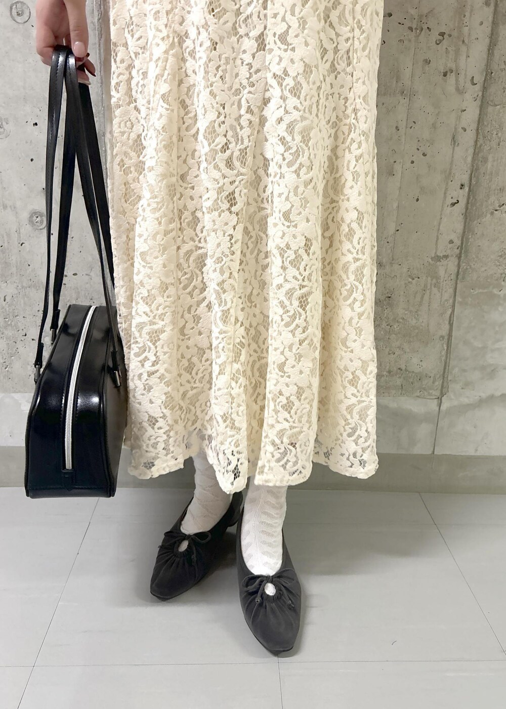 レッド系のニット/セーター、グレー系のパンプス、ブラック系のボストンバッグを着用したレディースの秋コーディネートの7枚目の写真