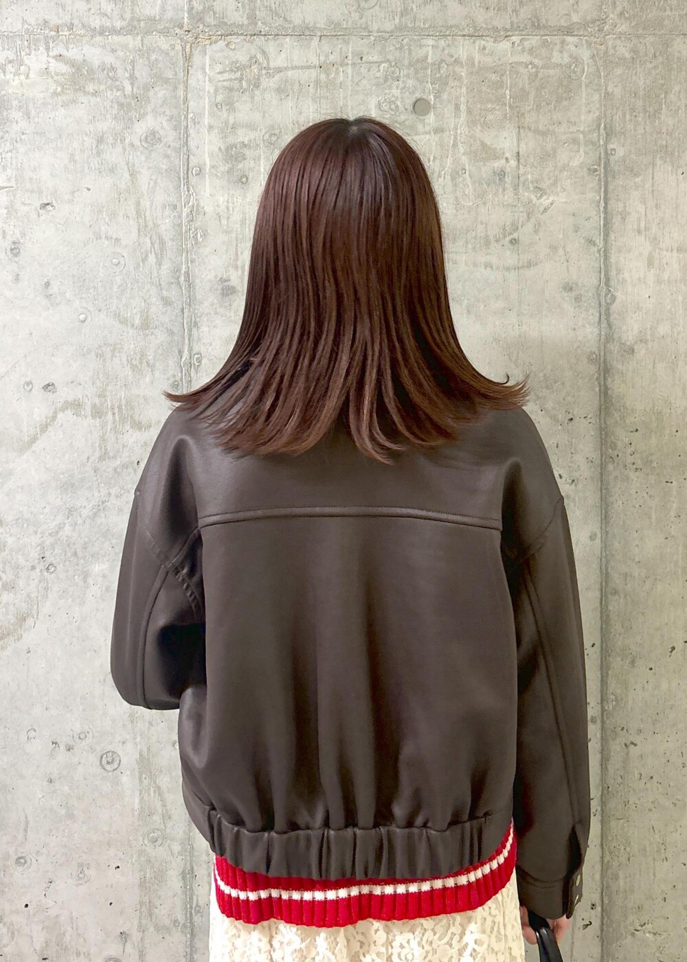 レッド系のニット/セーター、グレー系のパンプス、ブラック系のボストンバッグを着用したレディースの秋コーディネートの6枚目の写真