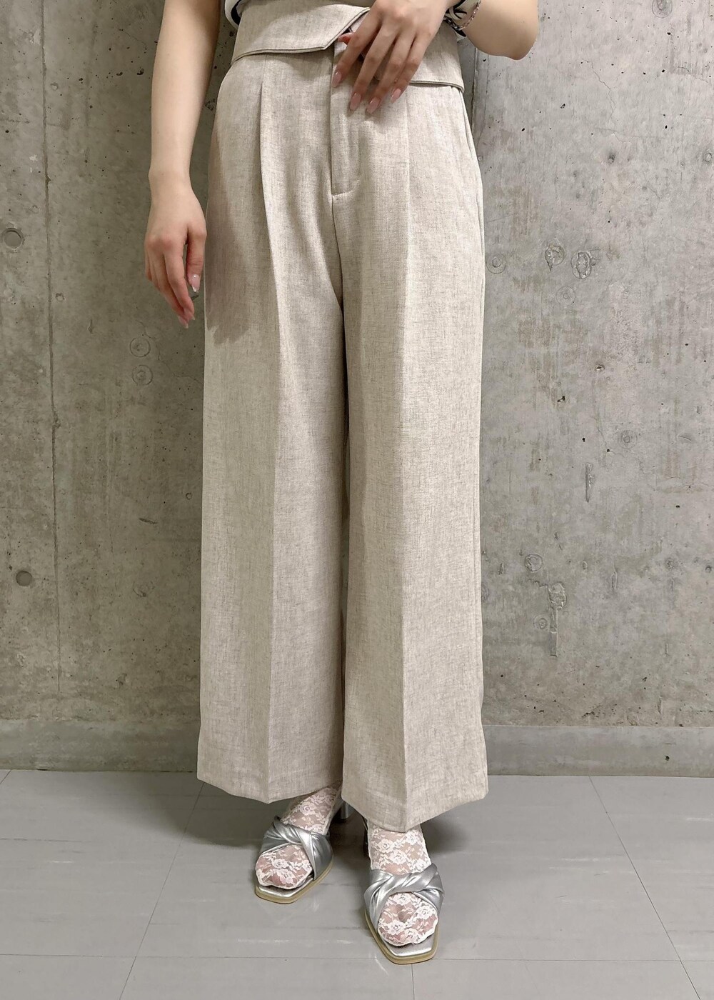 ホワイト系のニット/セーター、グレー系のショルダーバッグ、シルバー系のサンダルを着用したレディースの夏コーディネートの6枚目の写真