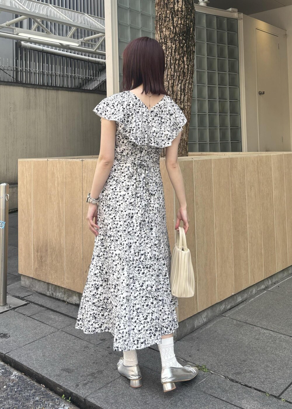 ホワイト系のハンドバッグ、シルバー系のパンプス、ホワイト系のワンピースを着用したレディースの春コーディネートの3枚目の写真