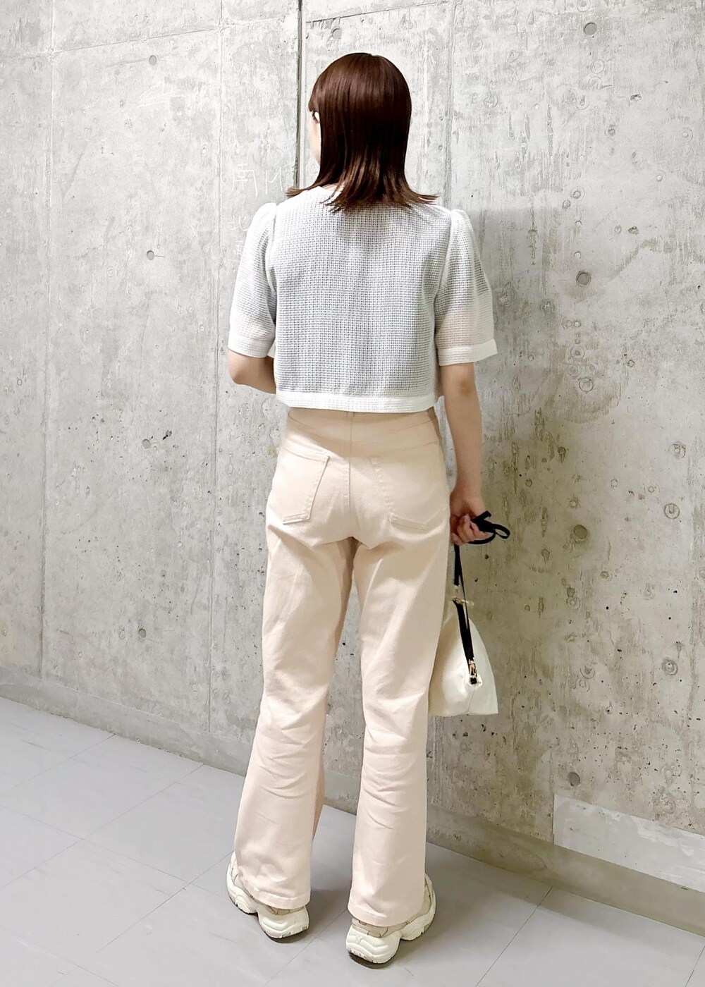 ホワイト系のノーカラージャケット、ホワイト系のショルダーバッグ、ブラック系のTシャツ/カットソーを着用したレディースの夏コーディネートの4枚目の写真