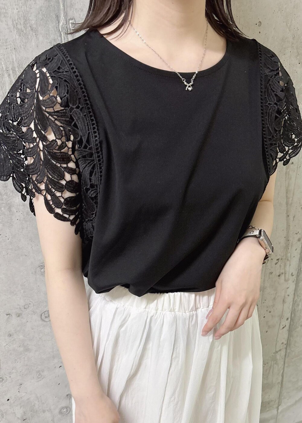 ホワイト系のスカート、ブラック系のTシャツ/カットソー、ブラック系のサンダルを着用したレディースの夏コーディネートの4枚目の写真