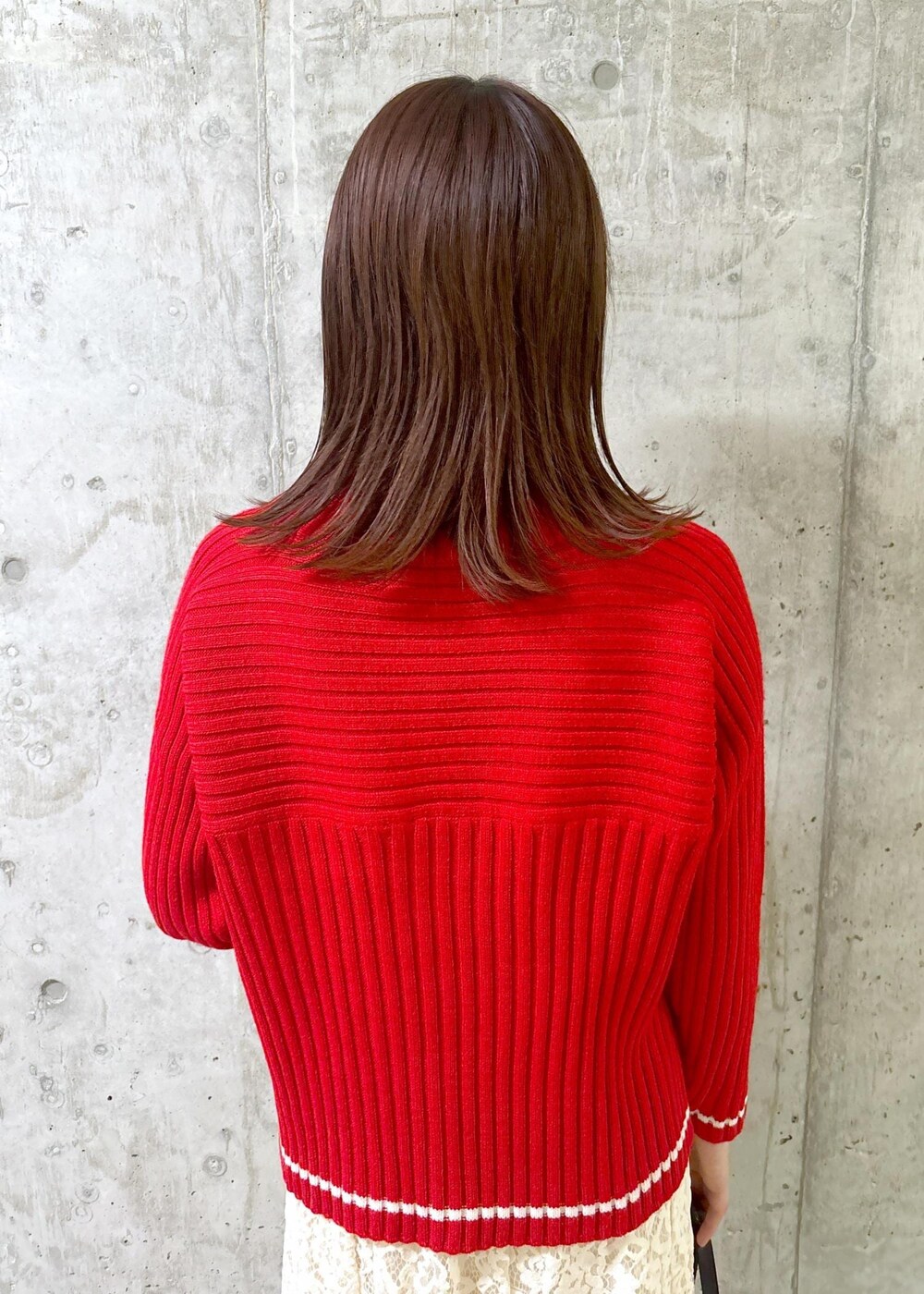 ホワイト系のスカート、レッド系のニット/セーター、グレー系のパンプスを着用したレディースの秋コーディネートの6枚目の写真