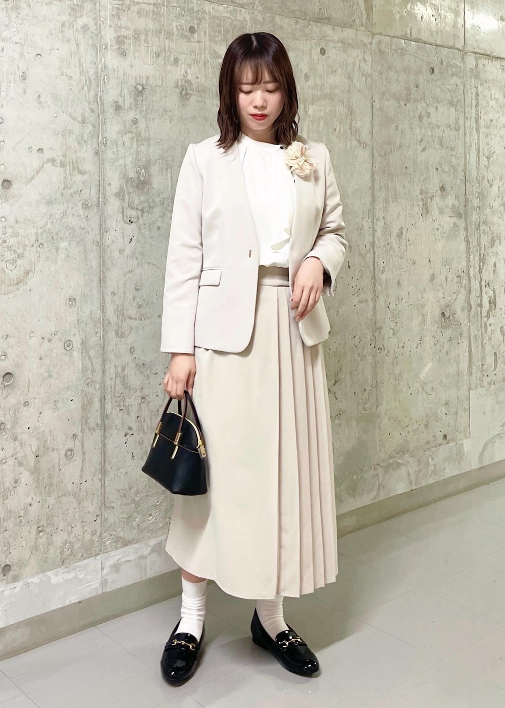 イエロー系のテーラードジャケット、ブラック系のローファー、ブラック系のショルダーバッグを着用したレディースの春コーディネートの2枚目の写真