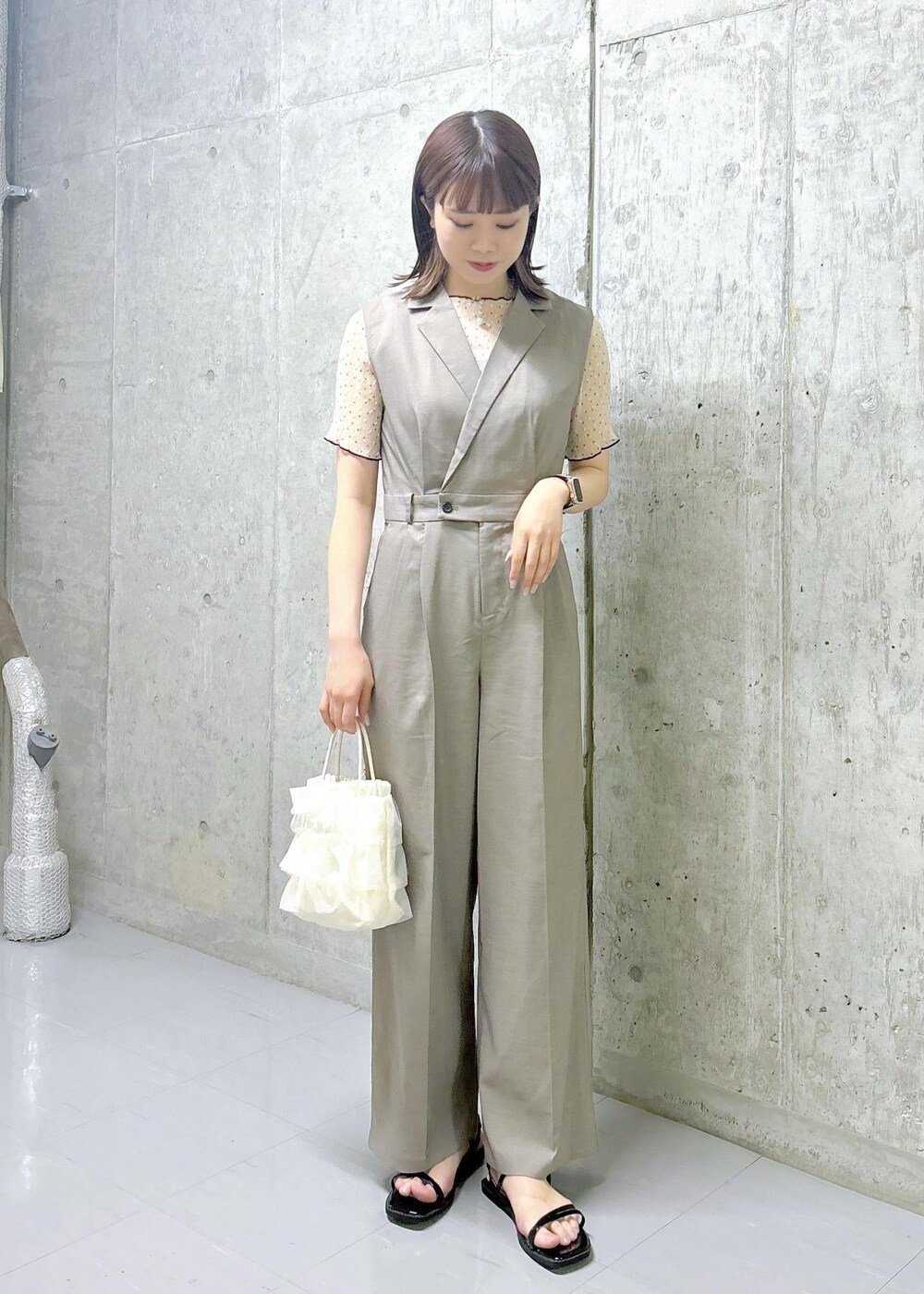 ブラック系のサンダル、ホワイト系のショルダーバッグ、ホワイト系のシャツ/ブラウスを着用したレディースの夏コーディネートの2枚目の写真