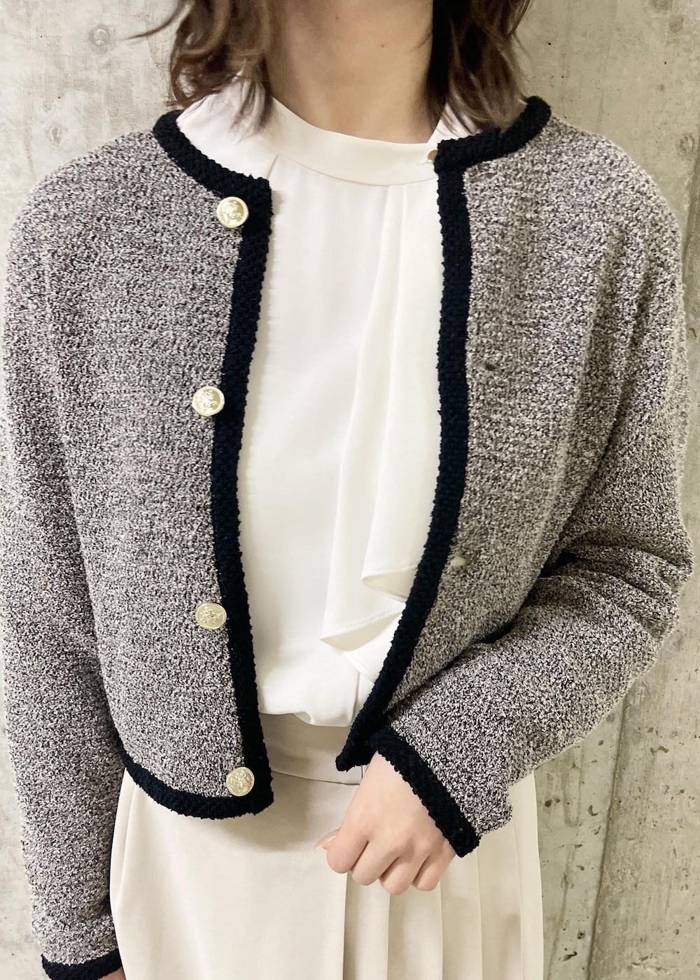 ブラック系のローファー、ブラック系のショルダーバッグ、ベージュ系のスカートを着用したレディースの春コーディネートの4枚目の写真