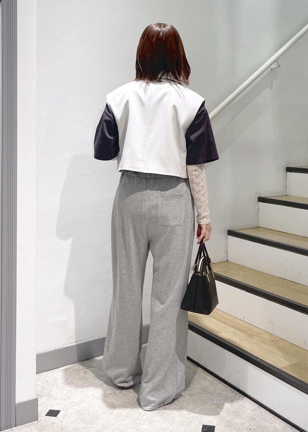 ホワイト系のTシャツ/カットソー、ブラック系のショルダーバッグ、シルバー系のパンプスを着用したレディースの春コーディネートの4枚目の写真