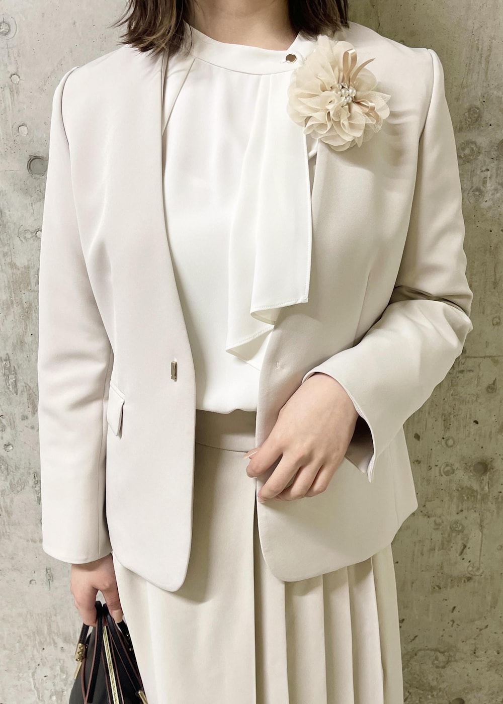 イエロー系のテーラードジャケット、ブラック系のローファー、ブラック系のショルダーバッグを着用したレディースの春コーディネートの5枚目の写真