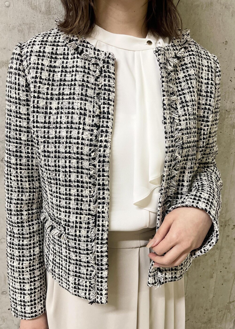 ブラック系のローファー、ブラック系のノーカラージャケット、ブラック系のショルダーバッグを着用したレディースの春コーディネートの5枚目の写真