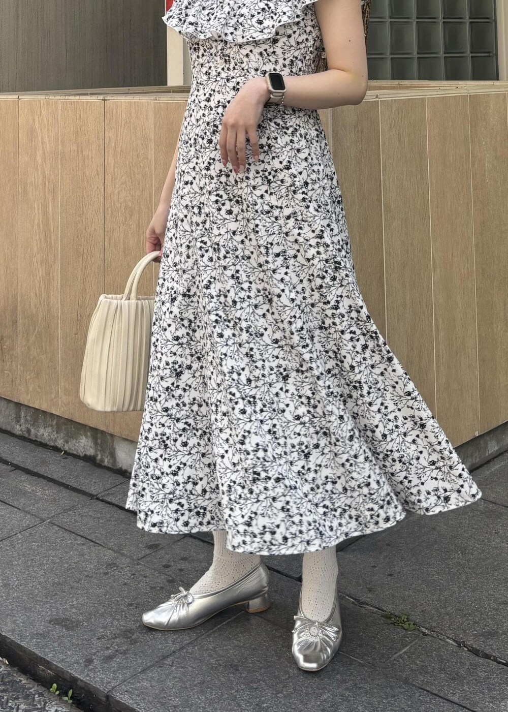 ホワイト系のハンドバッグ、シルバー系のパンプス、ホワイト系のワンピースを着用したレディースの春コーディネートの5枚目の写真