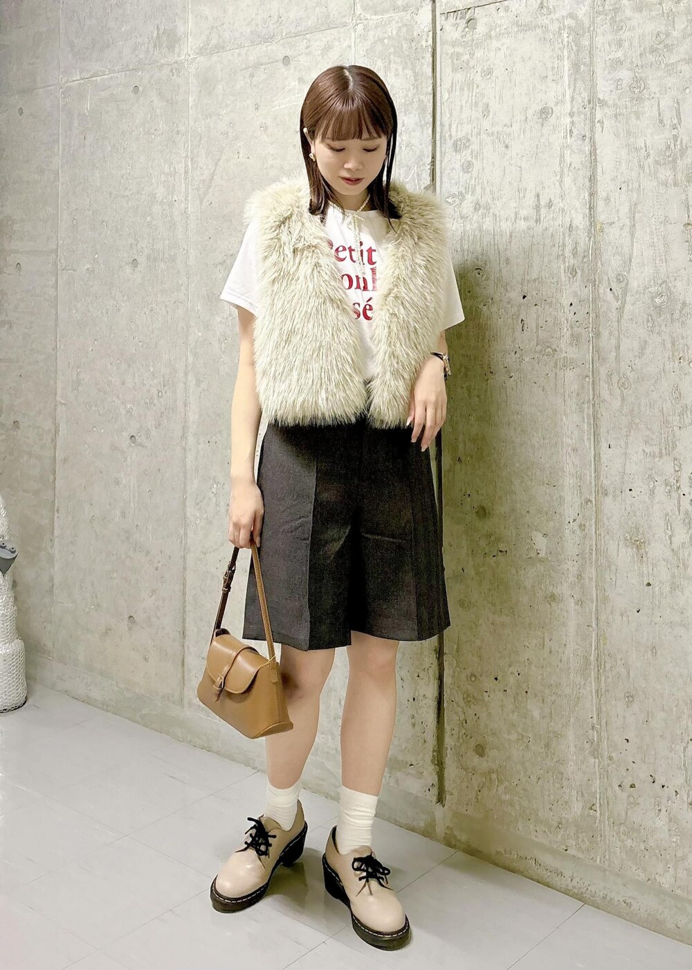 ベージュ系のベスト、ホワイト系のTシャツ/カットソー、ブラウン系のその他パンツを着用したレディースの秋コーディネートの2枚目の写真