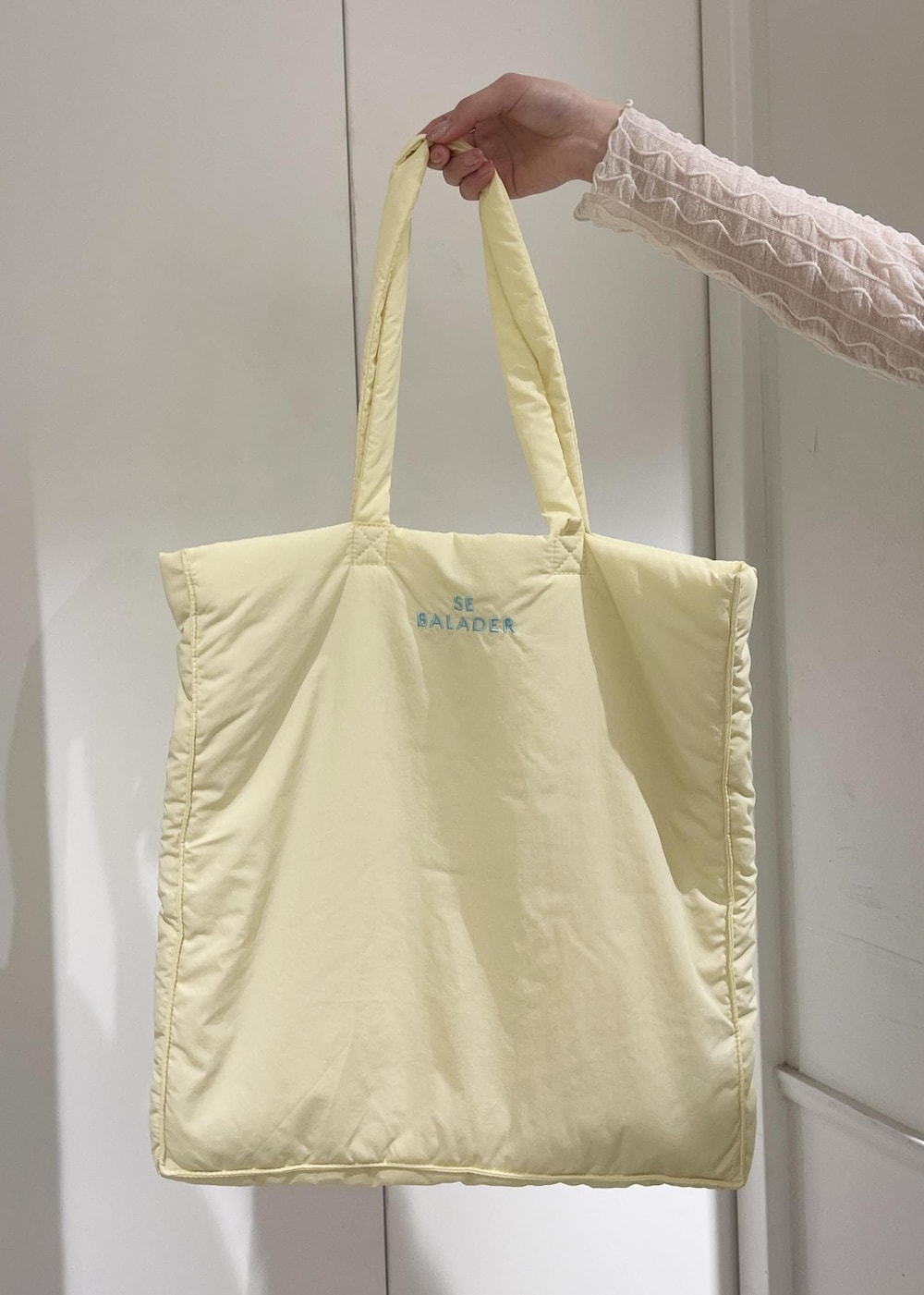 ホワイト系のTシャツ/カットソー、シルバー系のパンプス、イエロー系のトートバッグを着用したレディースの春コーディネートの6枚目の写真