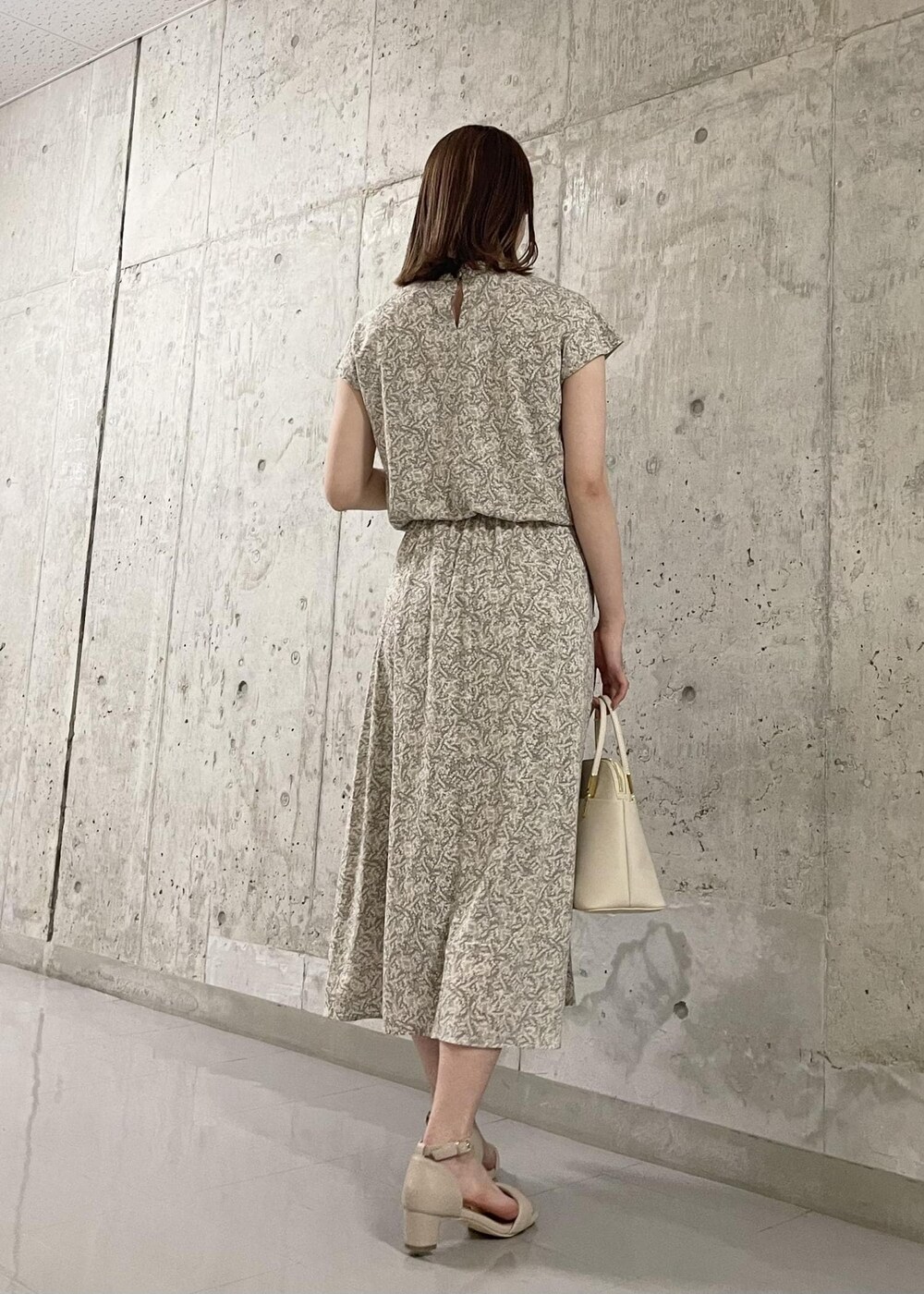 ベージュ系のサンダル、ホワイト系のショルダーバッグ、ベージュ系のワンピースを着用したレディースの春コーディネートの3枚目の写真