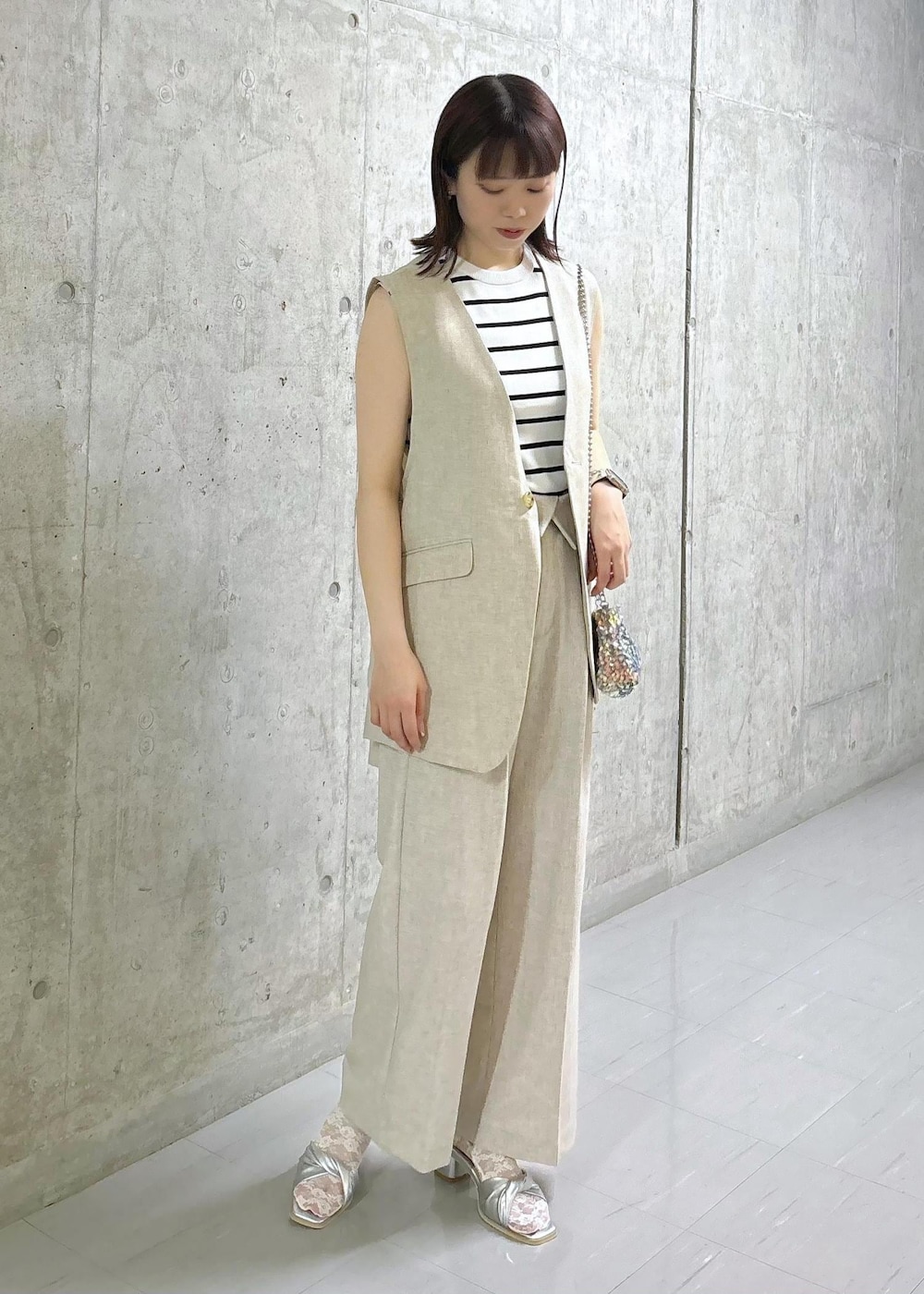 ホワイト系のニット/セーター、グレー系のショルダーバッグ、シルバー系のサンダルを着用したレディースの夏コーディネートの3枚目の写真