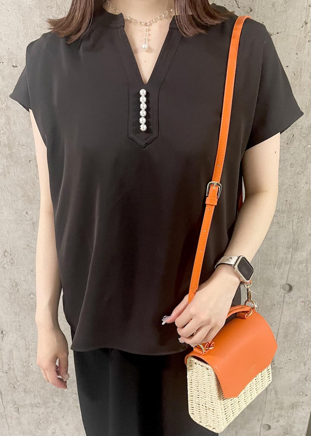 オレンジ系のショルダーバッグ、ブラック系のサンダル、ブラック系のワンピースを着用したレディースの夏コーディネートの4枚目の写真