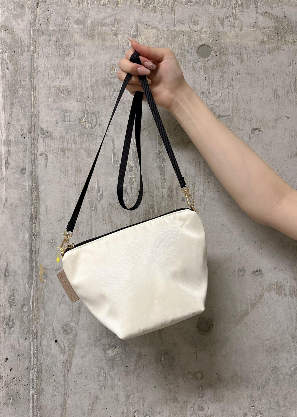 ホワイト系のノーカラージャケット、ホワイト系のショルダーバッグ、ブラック系のTシャツ/カットソーを着用したレディースの夏コーディネートの9枚目の写真