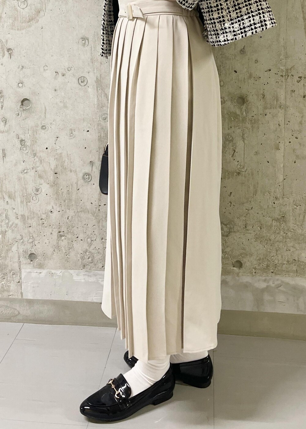 ブラック系のローファー、ブラック系のノーカラージャケット、ブラック系のショルダーバッグを着用したレディースの春コーディネートの7枚目の写真