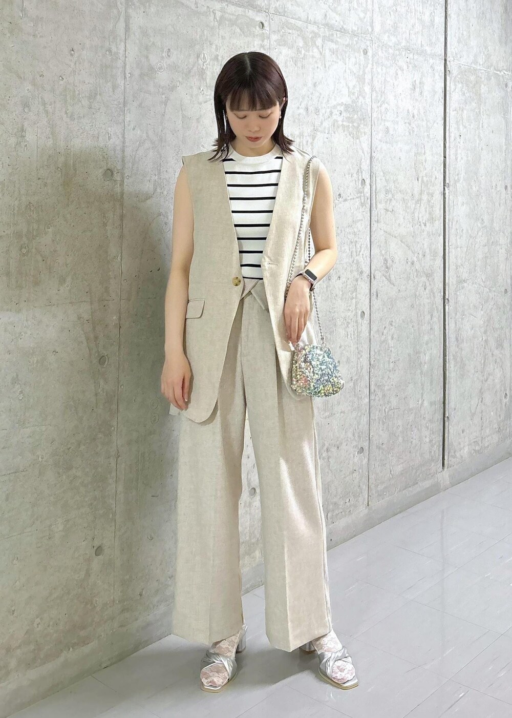 ホワイト系のニット/セーター、グレー系のショルダーバッグ、シルバー系のサンダルを着用したレディースの夏コーディネートの2枚目の写真