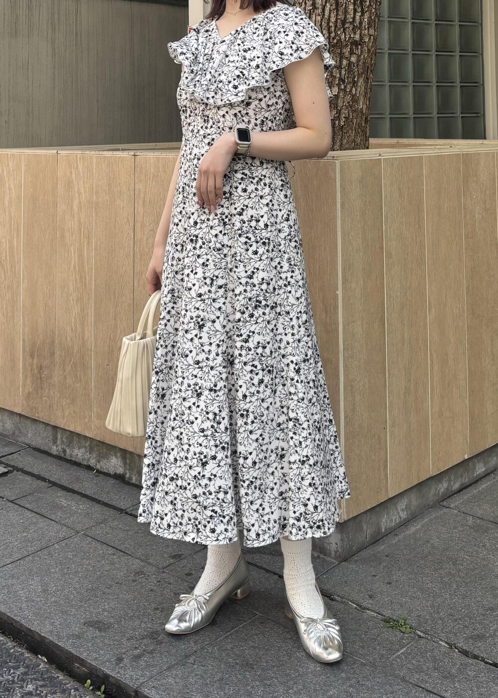 ホワイト系のハンドバッグ、シルバー系のパンプス、ホワイト系のワンピースを着用したレディースの春コーディネートの2枚目の写真