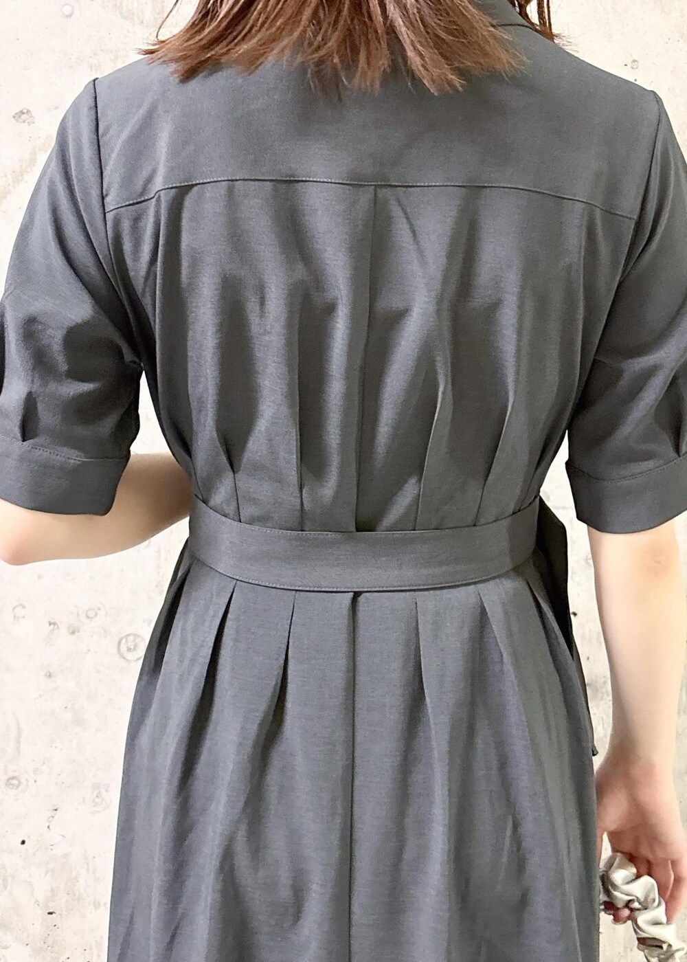 シルバー系のパンプス、グレー系のシャツワンピース、シルバー系のハンドバッグを着用したレディースの夏コーディネートの7枚目の写真