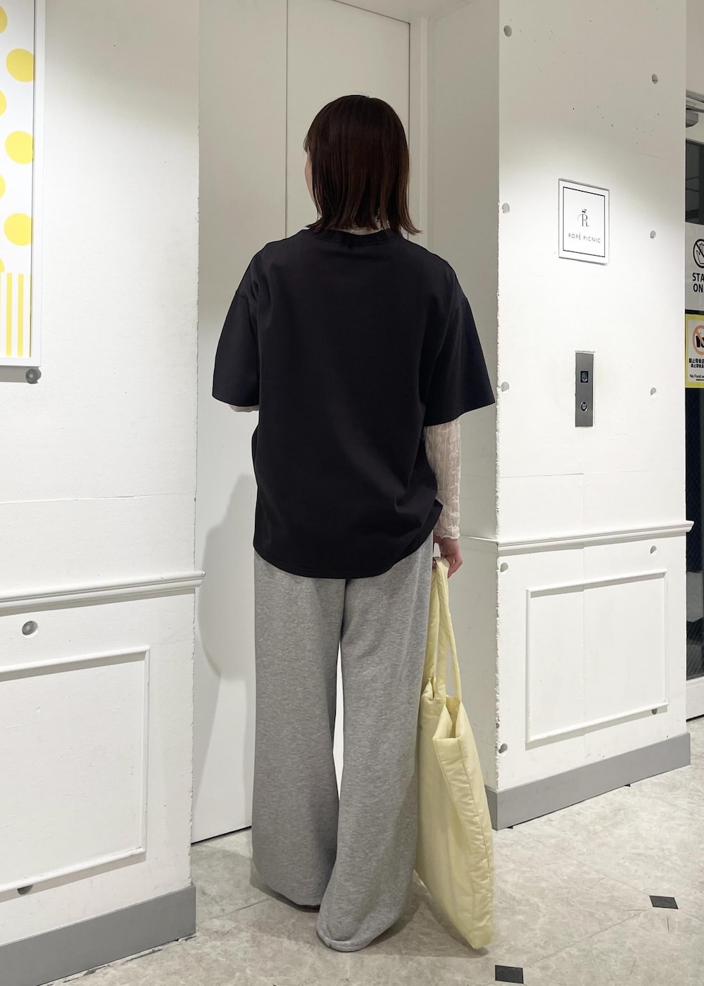 ホワイト系のTシャツ/カットソー、シルバー系のパンプス、イエロー系のトートバッグを着用したレディースの春コーディネートの2枚目の写真