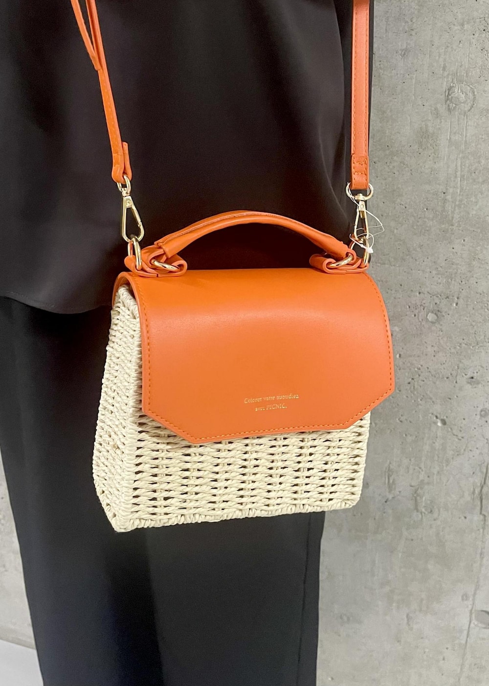 オレンジ系のショルダーバッグ、ブラック系のサンダル、ブラック系のワンピースを着用したレディースの夏コーディネートの6枚目の写真