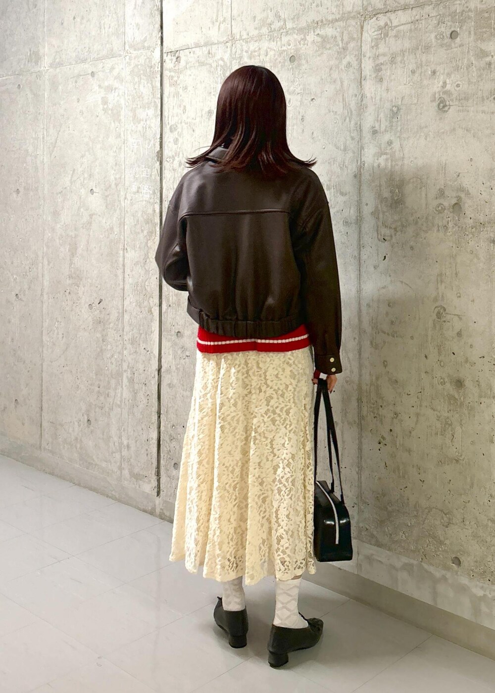 レッド系のニット/セーター、グレー系のパンプス、ブラック系のボストンバッグを着用したレディースの秋コーディネートの4枚目の写真