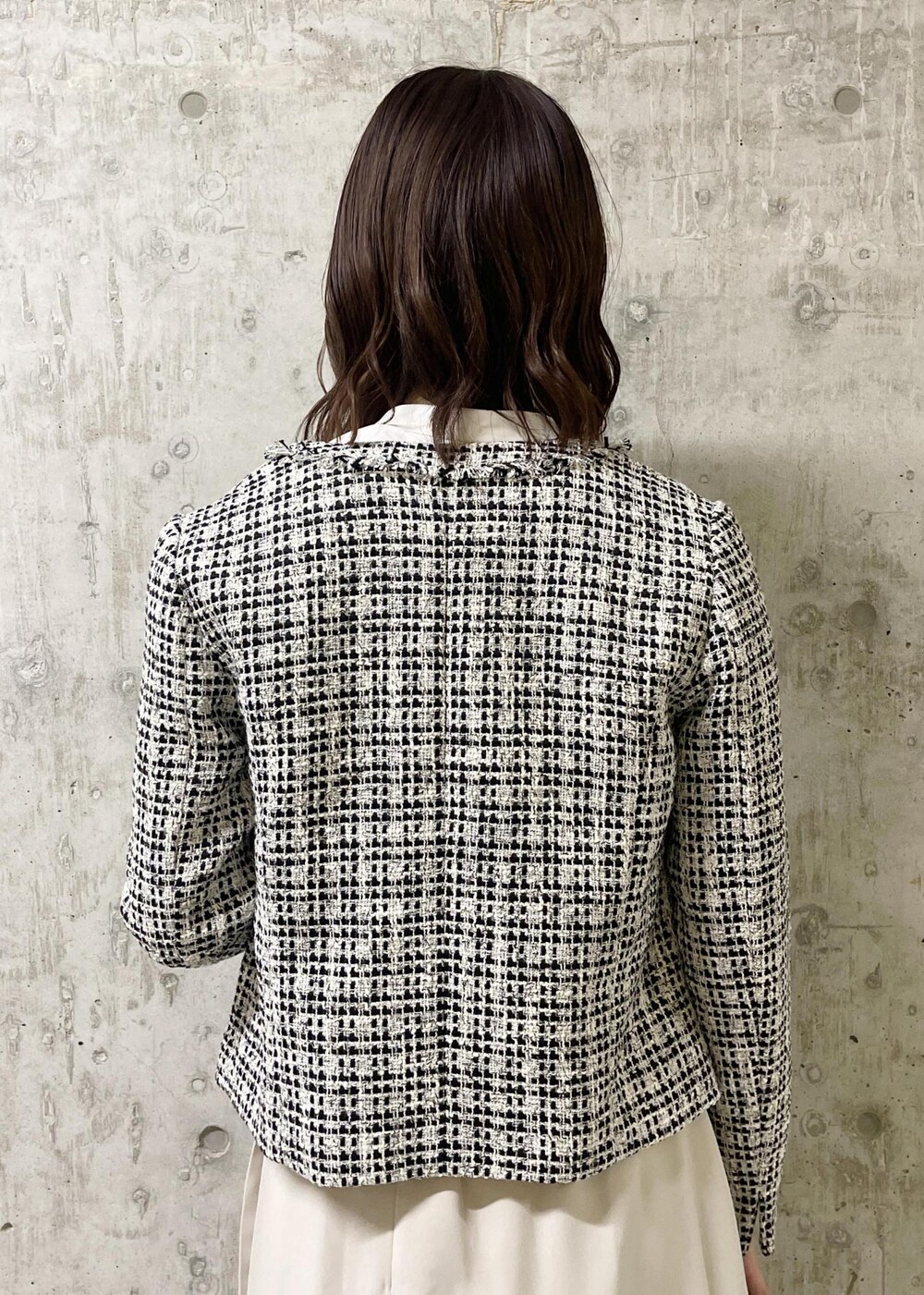 ブラック系のローファー、ブラック系のノーカラージャケット、ブラック系のショルダーバッグを着用したレディースの春コーディネートの6枚目の写真