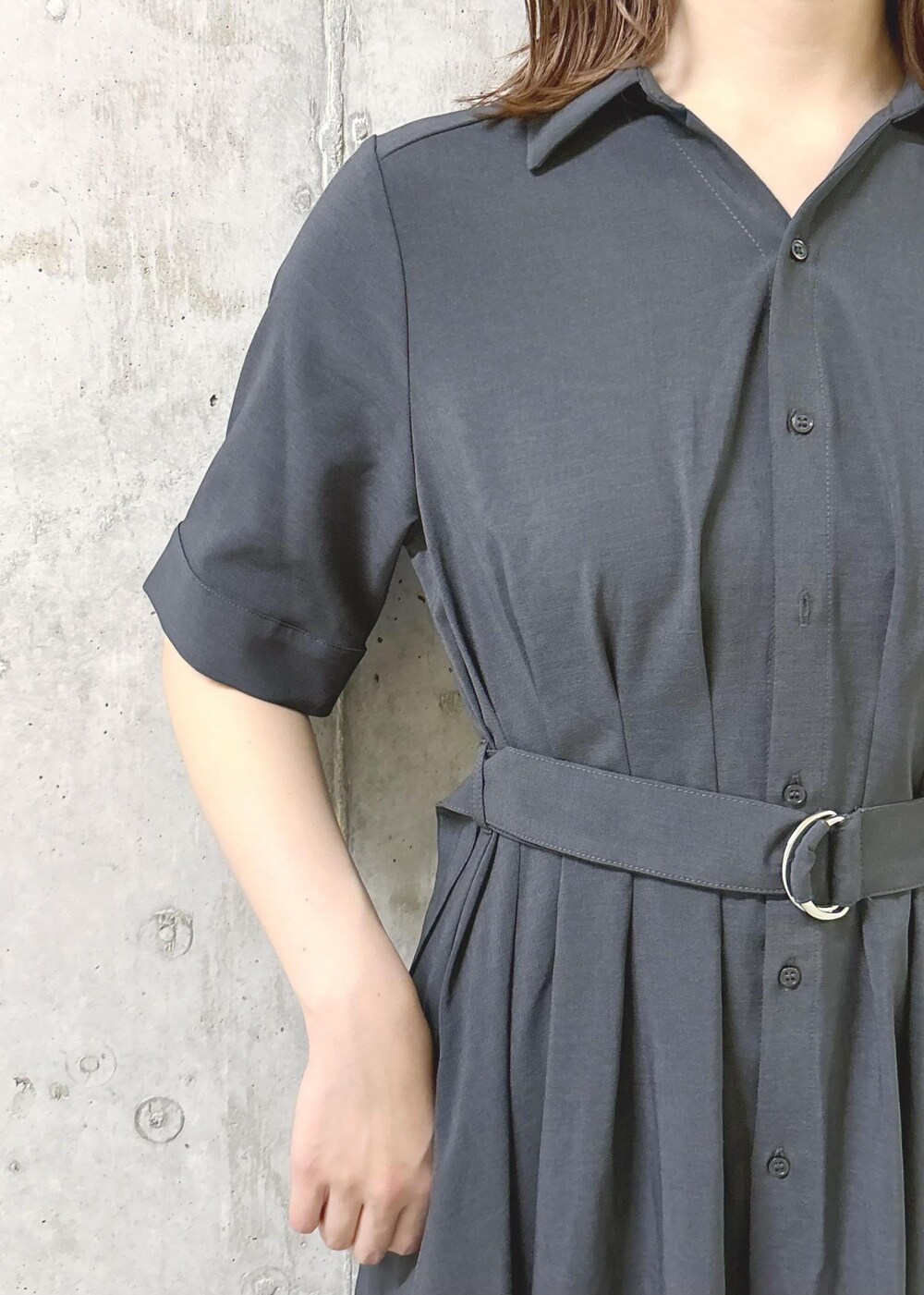 シルバー系のパンプス、グレー系のシャツワンピース、シルバー系のハンドバッグを着用したレディースの夏コーディネートの6枚目の写真