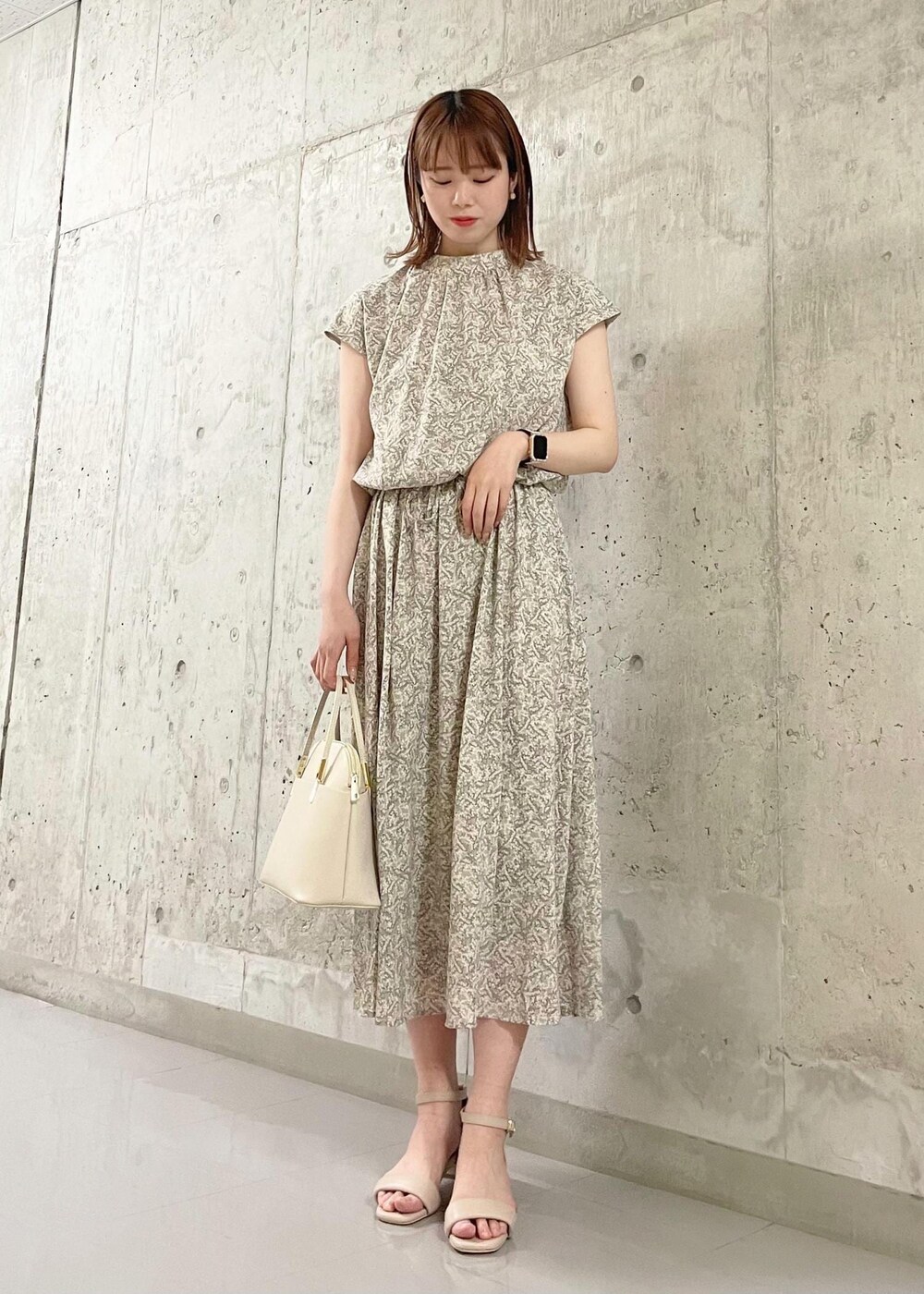 ベージュ系のサンダル、ホワイト系のショルダーバッグ、ベージュ系のワンピースを着用したレディースの春コーディネートの2枚目の写真