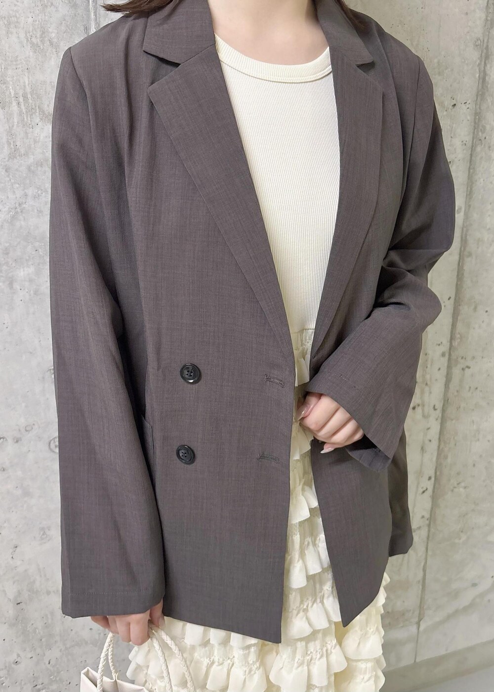 ホワイト系のワンピース、ゴールド系のサンダル、ブラウン系のテーラードジャケットを着用したレディースの夏コーディネートの6枚目の写真