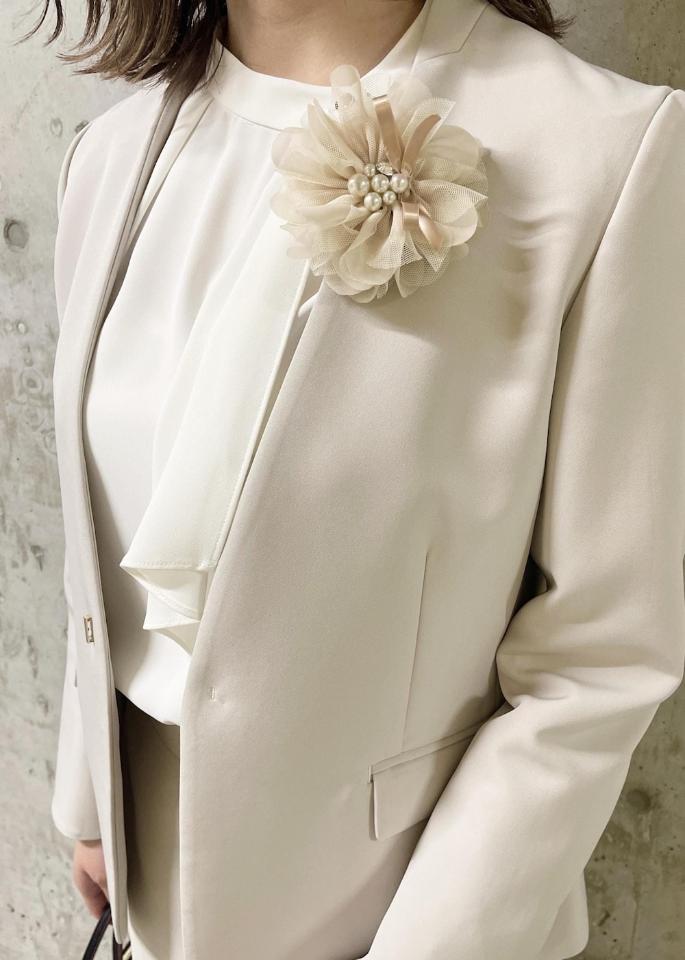 イエロー系のテーラードジャケット、ブラック系のローファー、ブラック系のショルダーバッグを着用したレディースの春コーディネートの6枚目の写真