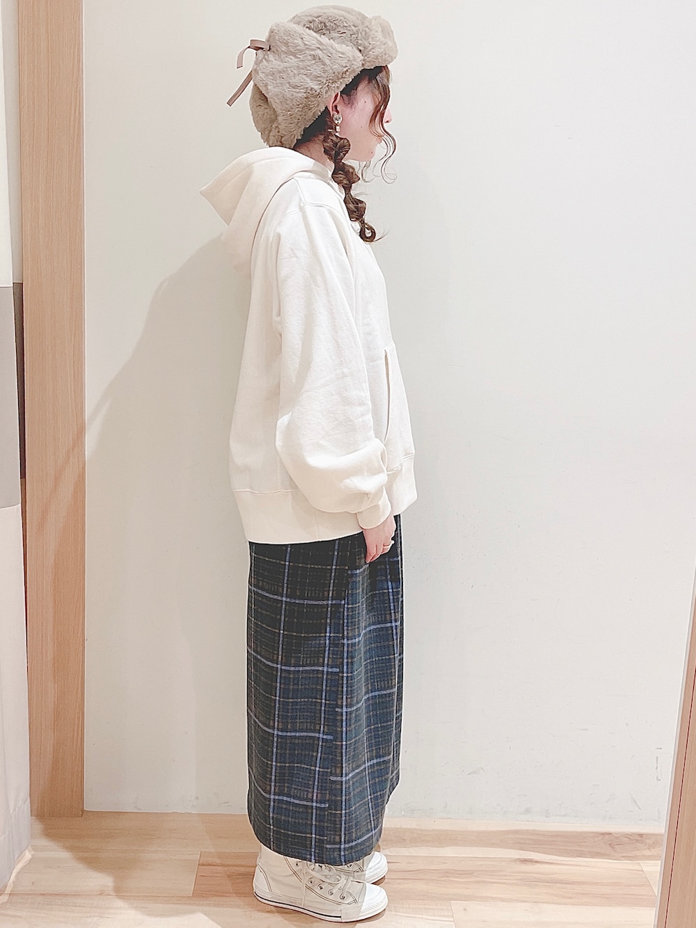 ホワイト系のパーカー、グリーン系のスカート、ホワイト系のスニーカーを着用したレディースの秋コーディネートの3枚目の写真