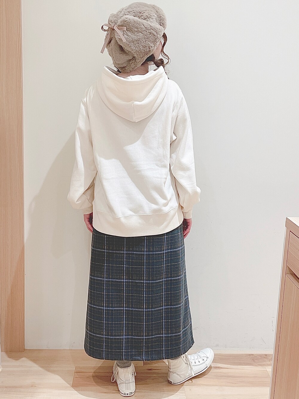 ホワイト系のパーカー、グリーン系のスカート、ホワイト系のスニーカーを着用したレディースの秋コーディネートの4枚目の写真